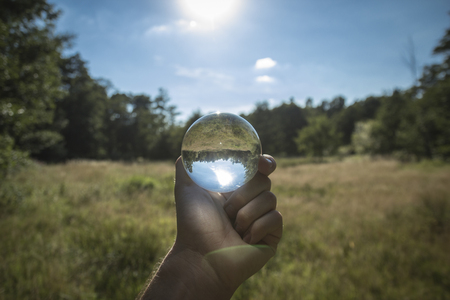 Glass sphere in front of a meadowの写真素材