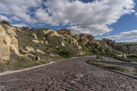 street and rock formation in cappadociaの写真素材