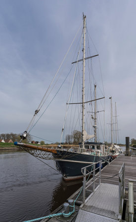 picture of a sailing ship on a pier in a little riverの写真素材