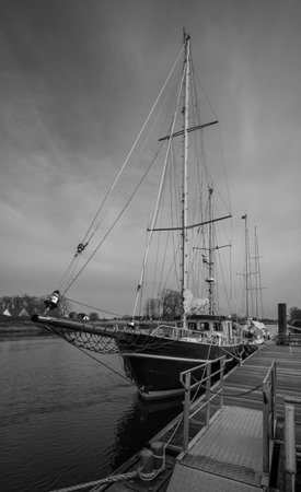 picture of a sailing ship on a pier in a little riverの写真素材