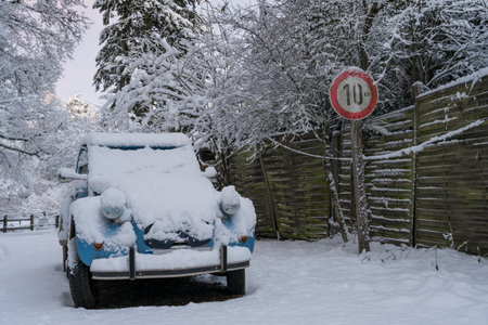 Old classic car in a snowy, rural landscape.の写真素材