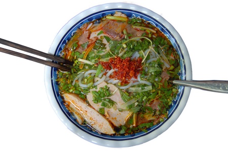 A bowl of Vietnamese spicy beef noodle (bun bo Hue), top view, isolated on white