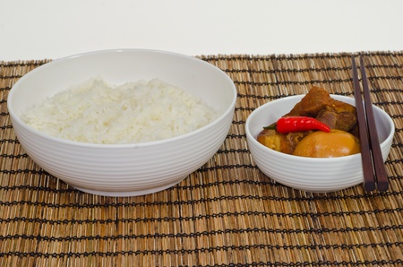 Vietnamese Pork Stew with Hard Boiled Egg  Thit Kho Hot Vit  served with steamed rice, on bamboo trayの写真素材