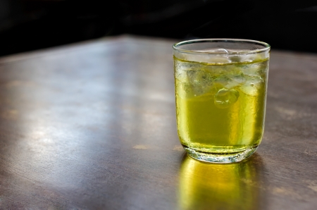 A glass of iced tea isolated on reflecting table, black backgroundの写真素材