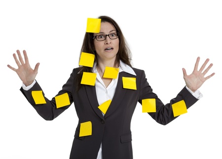 Stressed out business woman with numerous post-it notes stuck on her. White background.の写真素材