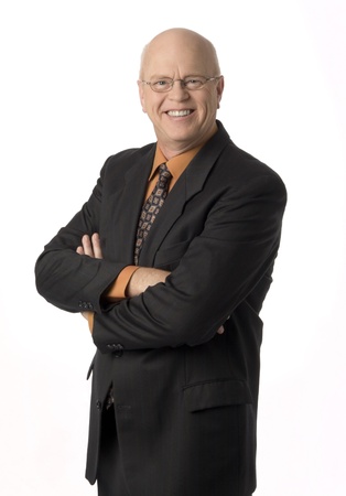 Pleasant mature businessman standing with arms crossed, isolated on white background.の写真素材