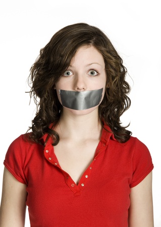 Studio photo of teenage girl with mouth taped closed on white background.の写真素材