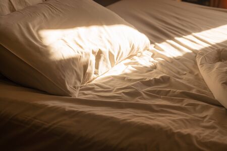 white pillow on bed after wake up with sunshine from window in the morning