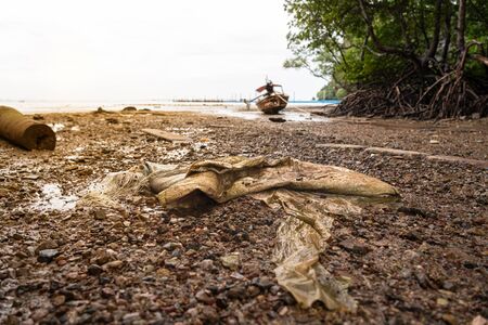 the garbage on beautiful beach while tide down sea in the morningの写真素材