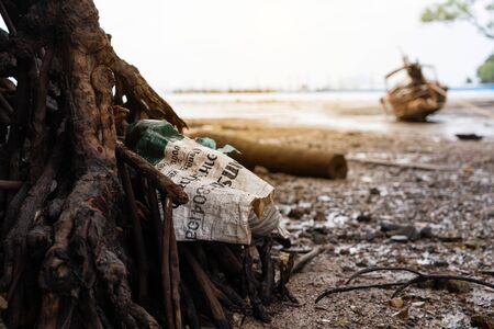 the garbage on beautiful beach while tide down sea in the morningの写真素材