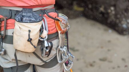 a man with red shirt climbing on the cliff with equipmentの写真素材