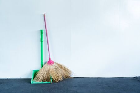 Bloom and dustpan put together on the white wallの写真素材