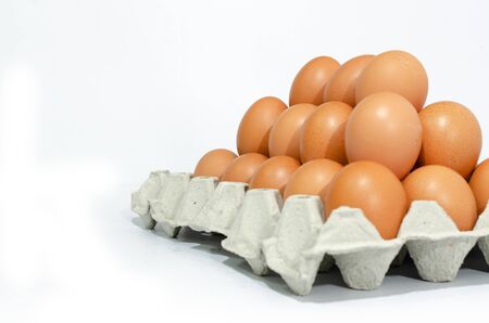 A lot of eggs put on tray on white background and one of these was broke