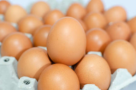 A lot of eggs put on tray on white background and one of these was brokeの写真素材