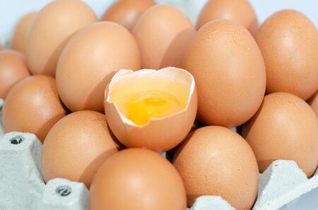 A lot of eggs put on tray on white background and one of these was brokeの写真素材