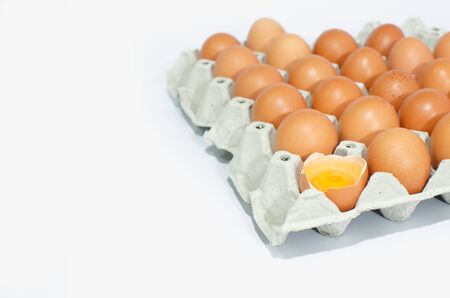 A lot of eggs put on tray on white background and one of these was brokeの写真素材