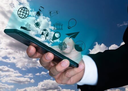 a hand's business man using smartphone with business icon jump out from screen in cloud sky background, business icon conceptの写真素材