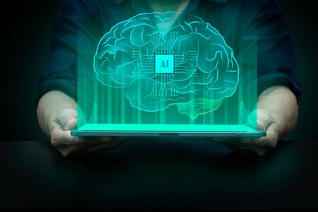 Artificial intelligence concept, glowing AI cpu putting in human brain showing on tabletの写真素材