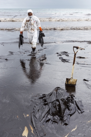 RAYONG, THAILAND - JULY 31, 2013  A worker in biohazard suit during the clean-up operation from crude oil spilled into Ao Prao Beach on July 31, 2013 in Rayong province, Thailand のeditorial素材