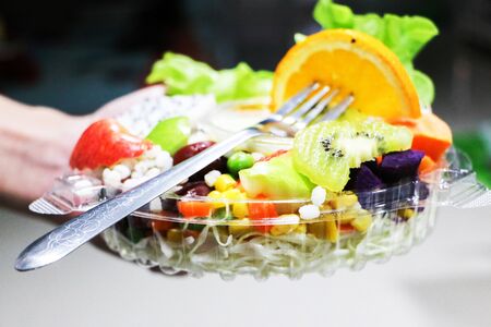Practice dipping fresh healthy fruit salad in a box.