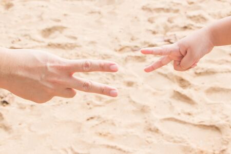 Father's and fists' hands shot rock-paper-scissors at the seasideの写真素材