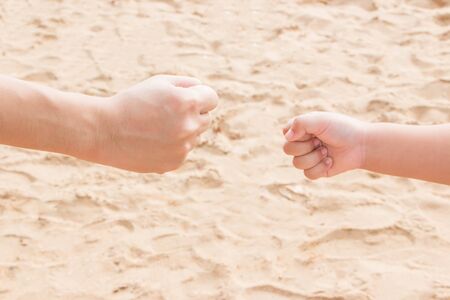 Father's and fists' hands shot rock-paper-scissors at the seasideの写真素材