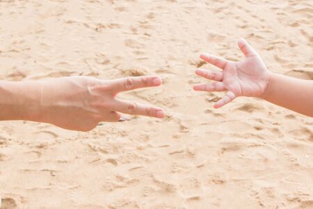 Father's and fists' hands shot rock-paper-scissors at the seasideの写真素材