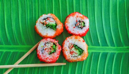 Sushi on a tray of green food like banana leavesの写真素材