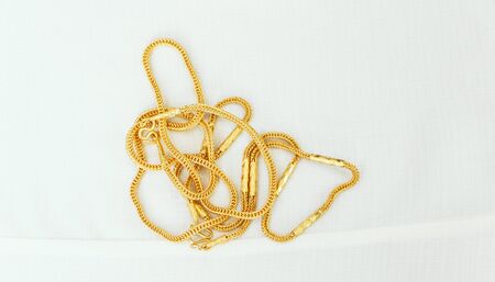 Two gold necklaces on a white backgroundの写真素材