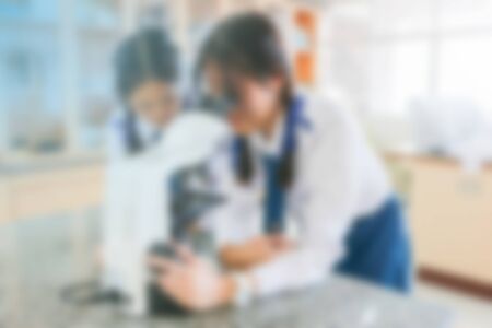 Blurred images, students look at the microscope in the science laboratoryの写真素材