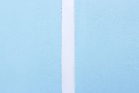 The blue cement wall contrasts with the white color.