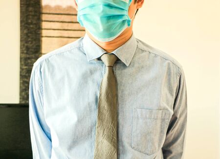 A man wearing a sanitary mask wearing a blue shirtの写真素材