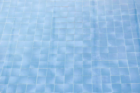 The blue tile floor of the pool