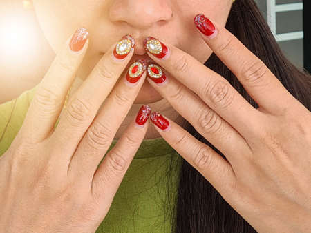 A woman showing a hand painted red nails