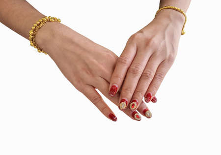 Red fingernails are beautifully decorated on a isolated bright white background.