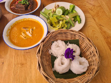 Thai rice noodles with crab curry sauce and fresh vegetables.の写真素材