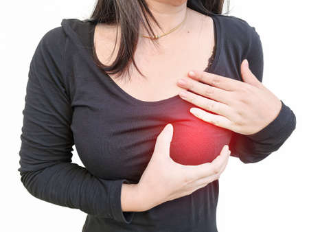 A close-up of a woman with chest pain and touching the heart area.の写真素材