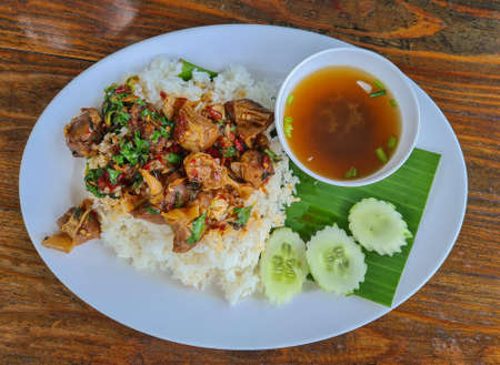 Holy Basil Fried Rice with Pork Braised in a White Plate on a Wooden Tableの写真素材