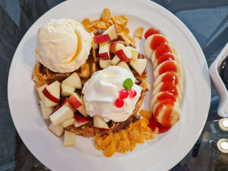 Whipped cream and waffles topped with fruitの写真素材