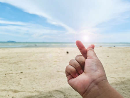 Small heart hands on blurry sea and sky background. Use for love world or valentine concept.の写真素材
