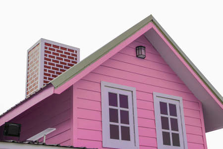 The pink triangular roof and red chimney have small solar panels mounted on isolated white background.の写真素材