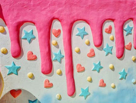 Pink dripping on a white plaster wall decorated with stars, circles, lovely hearts