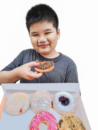 Happy boy eating donuts on isolated white background wall. Children having fun with donuts Delicious food for kids. Donuts and chocolate.の写真素材