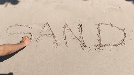 Hands of men writing a heart on beach.の写真素材