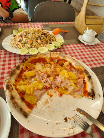 Pizza and seafood fried rice are placed on the dining table.の写真素材