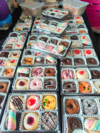 A delightful assortment of donuts, each adorned with colorful sprinkles, creamy frosting, and tempting chocolate glazeの写真素材