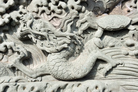 Typical Chinese carven dragon on wall expressing power and status in ancient thailandの写真素材