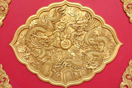 Double golden dragon in chinese style. On red wood.の写真素材