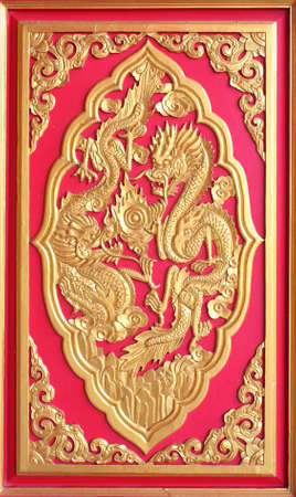 Double golden dragon in chinese style. On red wood.の写真素材