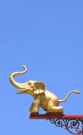 A golden elephant on postlamp with blue sky.の写真素材